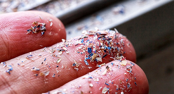 Close up side shot of microplastics lay on people hand.Concept of water pollution and global warming. Climate change idea.