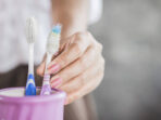 woman hand using old and destroy toothbrush closeup