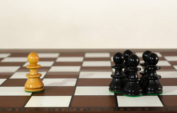 Wooden chess pieces grouped and single one. Bullyng and discrimination concept.