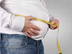 Overweight Man Measuring His Belly with tape measure