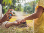dad and son use mosquito spray.Spraying insect repellent on skin outdoor.